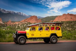 Yellow Willys Jeep in front of Garden of the Gods and Pikes Peak