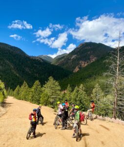 group of bike riders in forested canyon on dirt road