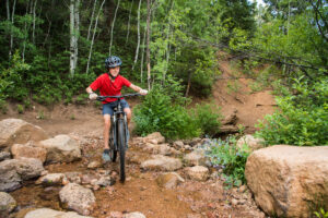 boy on a bike trail in the mountains steam crossing