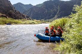 white water rafting group getting in boat on river