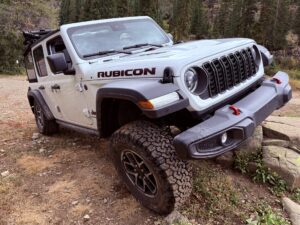 Jeep with all terrain tires on rocks and dirt road